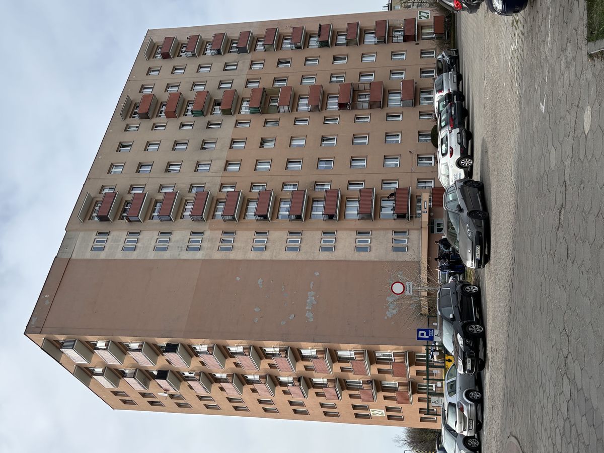 Blok mieszkalny nr 27 przed renowacją elewacji — zniszczona beżowa elewacja z ubytkami tynku