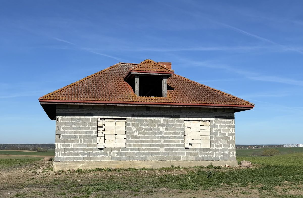 Budynek przed renowacją — surowe ściany z bloczków, stary dach