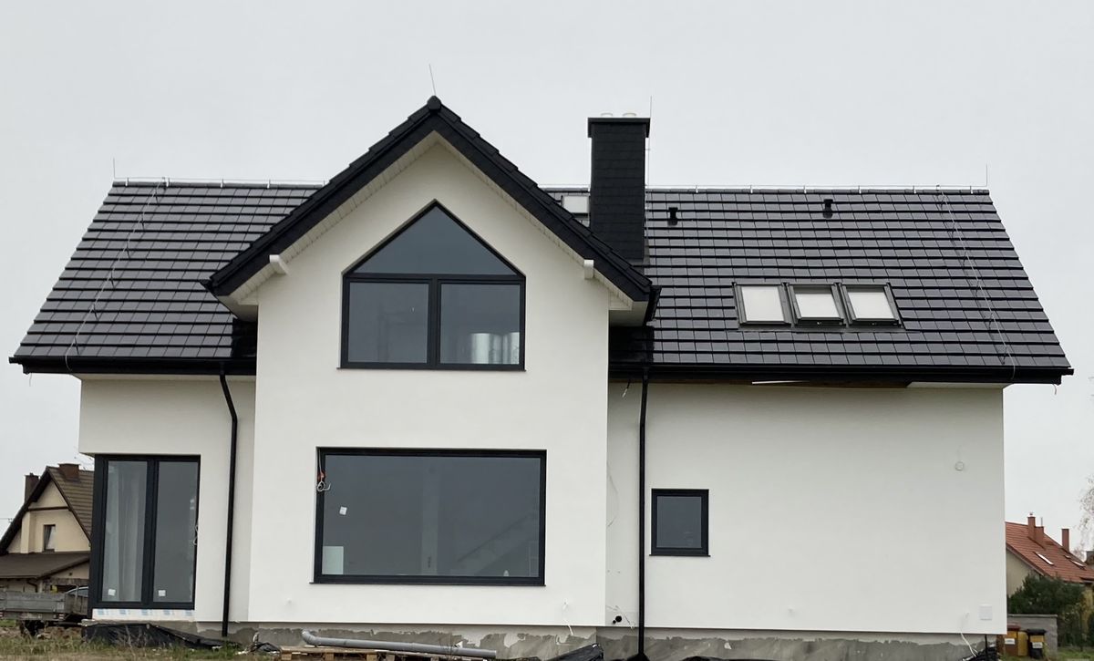 Dom jednorodzinny po wykonaniu elewacji — biała elewacja, ciemny dach, nowoczesny wygląd